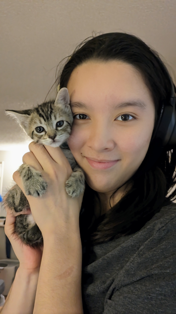 Tetra (young girl) holds a kitten up to her cheek